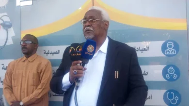 متحدث أمام ميكروفون في فعالية افتتاح منشأة صحية