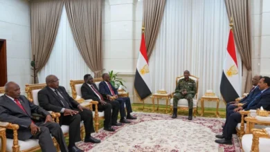لقاء رسمي في قاعة تضم العلم السوداني