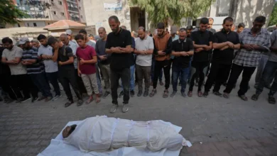 مشيعون يؤدون صلاة الجنازة أمام جثمان ملفوف بكفن في قطاع غزة