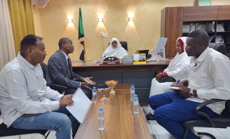 اجتماع رسمي حول طاولة تضم العلم السوداني