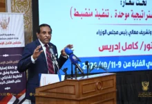 متحدث أمام منصة تحمل شعار ملتقى الأمل