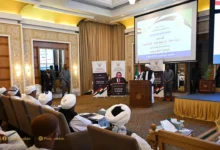 مشاركون في ملتقى داخل قاعة تعرض شاشة تقديمية