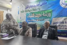 مشاركون في ورشة أمام لافتة عن المياه وحوض النيل