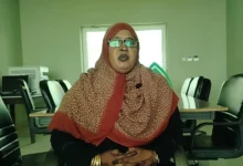 مسؤولة تتحدث داخل مكتب ذي مقاعد خضراء