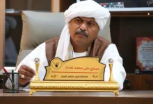 رجل يرتدي الزي التقليدي ويحمل لوحة تعريفية