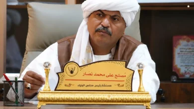 رجل يرتدي الزي التقليدي ويحمل لوحة تعريفية